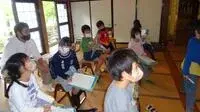 写真：屋内で説明を聞いている生徒とボランティアの様子