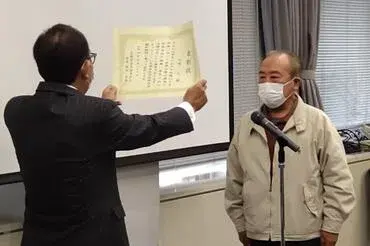 写真:市長から茨城県自治会連合会顕彰を手渡している様子1