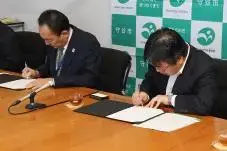 写真:協定書へサインをする様子
