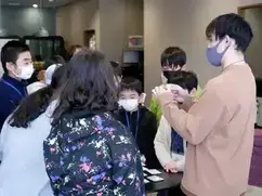 教育プログラムの様子イメージの写真（子どもたちに講師が近くで話している様子）