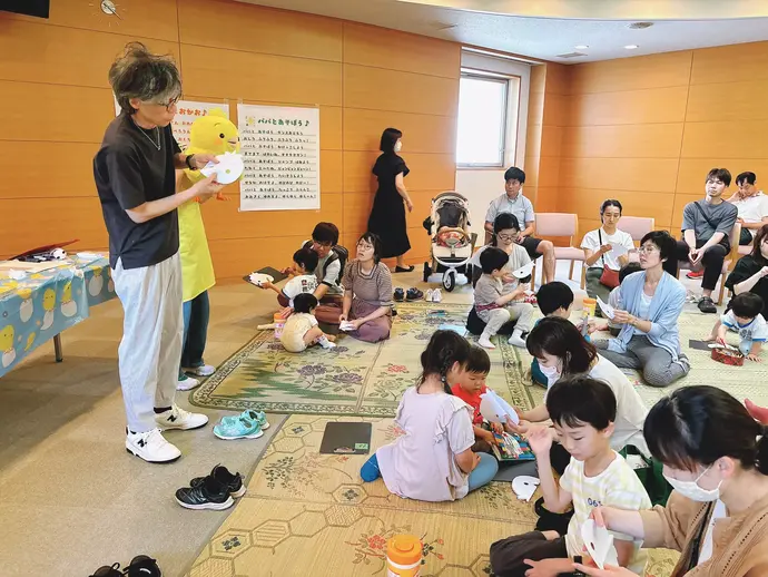 先生がお面の作り方を教える様子