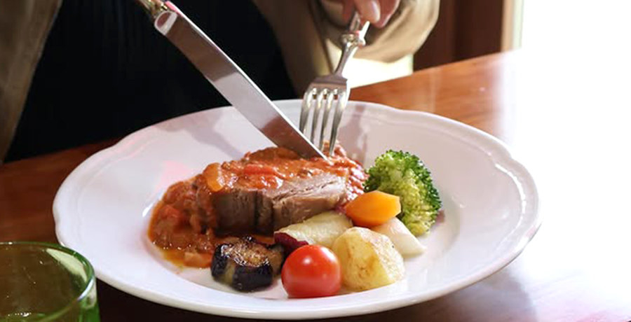 店内でお肉にナイフとフォークを入れている