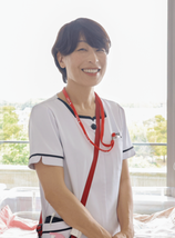 助産師さんが窓辺で微笑んでいる写真