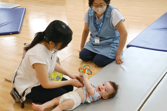 寝ている赤ちゃんを見ている写真