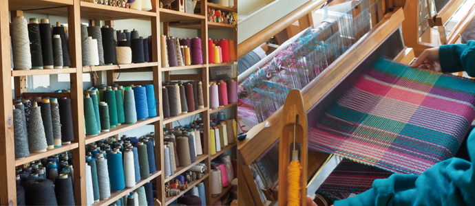 色とりどりの機織り用の糸が収められた棚と機織りの様子
